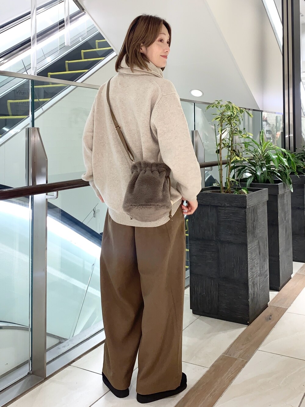 グレー系のその他パンツ、ベージュ系のニット/セーター、ブラウン系のショルダーバッグを着用したレディースの秋コーディネートの6枚目の写真