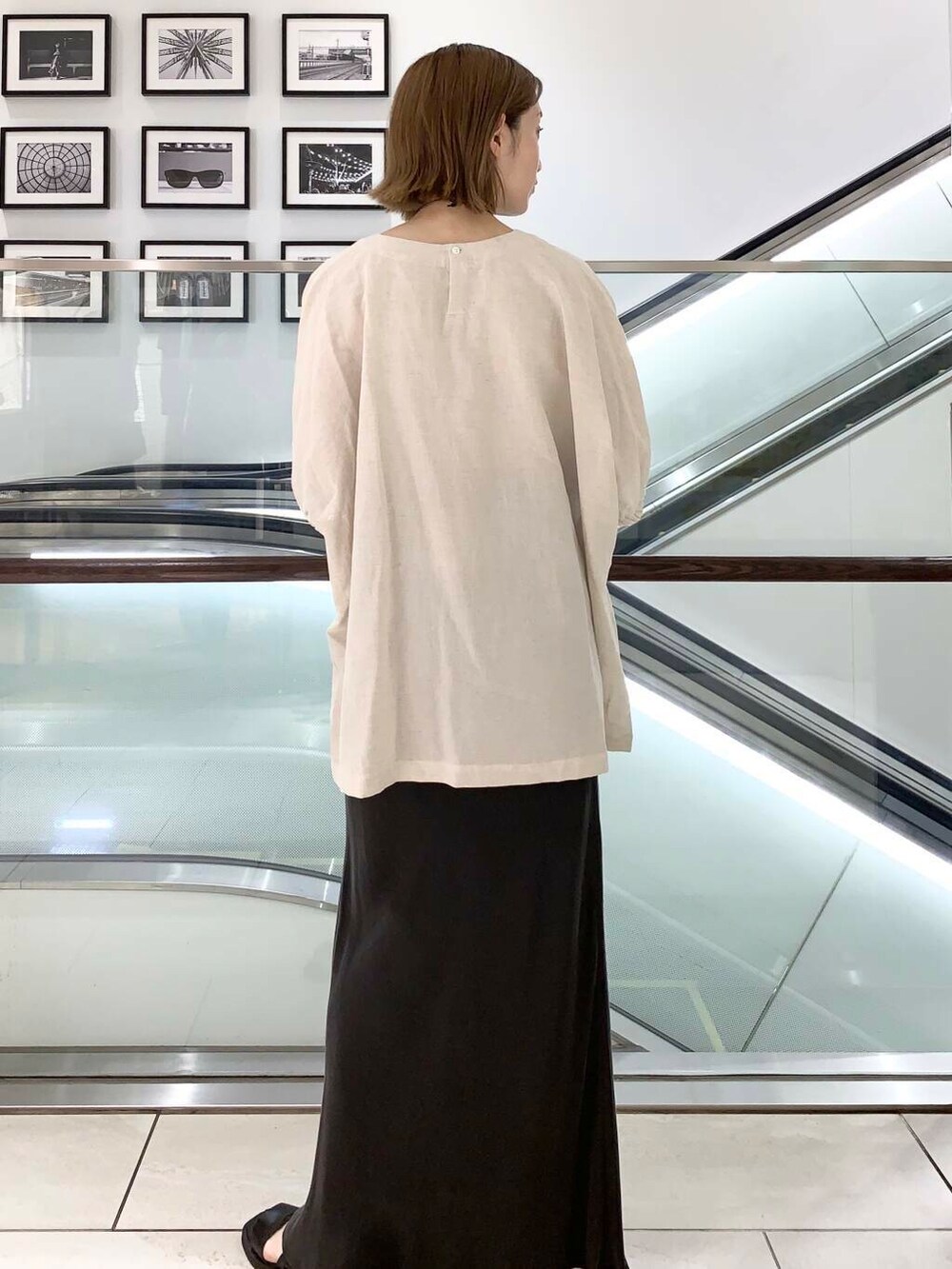 ブラック系のサンダル、ゴールド系のハンドバッグ、グレー系のスカートを着用したレディースの夏コーディネートの3枚目の写真