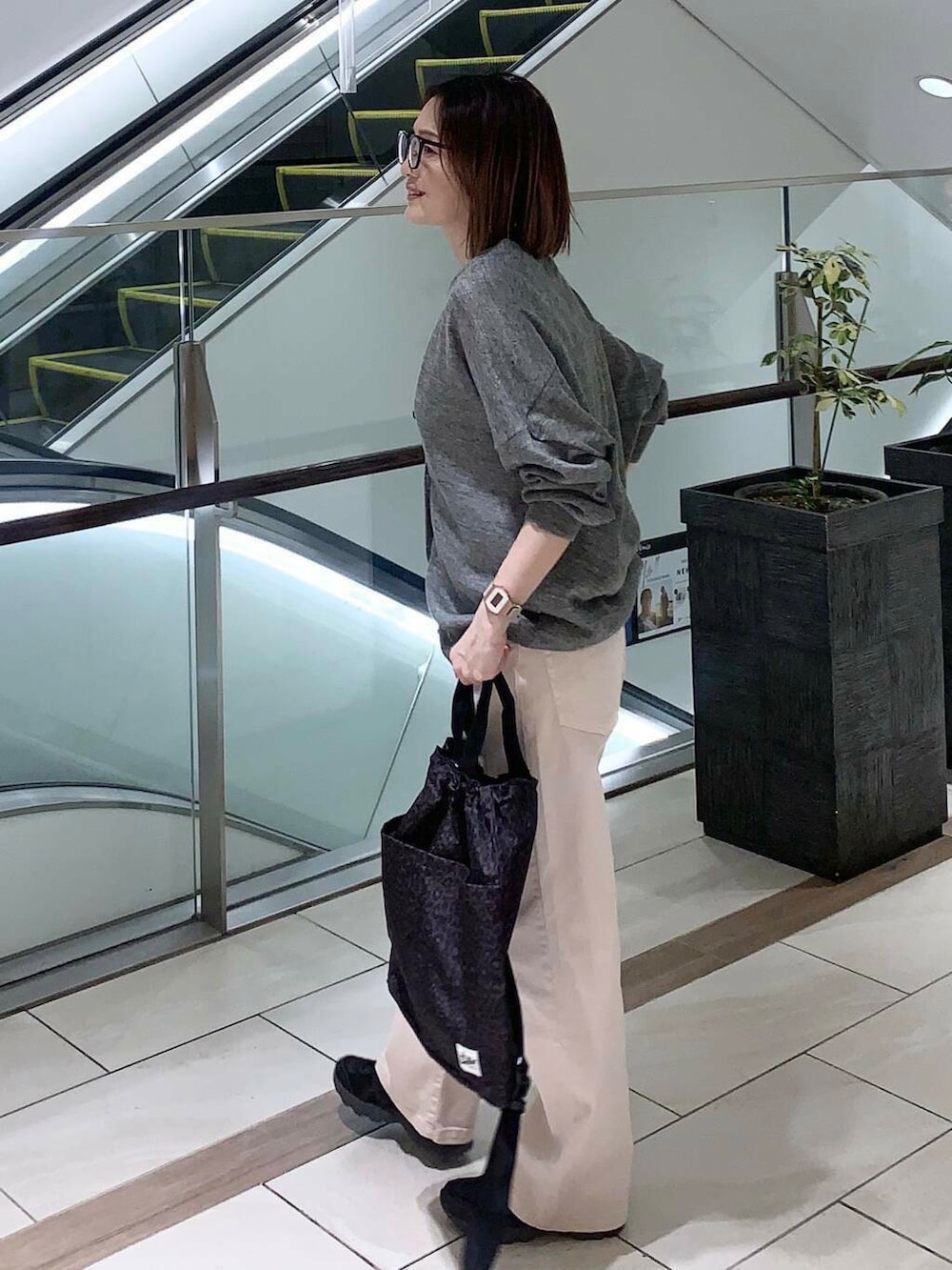 グレー系のカーディガン/ボレロ、ピンク系のその他パンツ、ブラック系のスニーカーを着用したレディースの春コーディネートの2枚目の写真