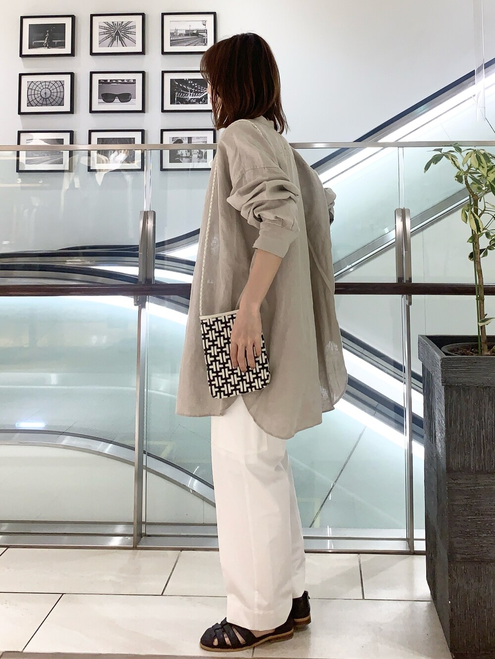 ブラック系のサンダル、ホワイト系のカーゴパンツ、ブラック系のショルダーバッグを着用したレディースの春コーディネートの2枚目の写真