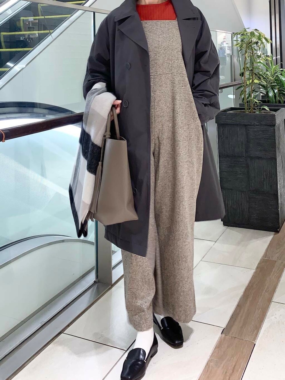 ブラック系のローファー、ブラック系のボストンバッグ、オレンジ系のニット/セーターを着用したレディースの秋コーディネートの5枚目の写真