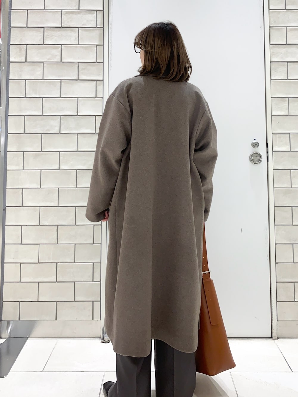 ブラウン系のその他アウター、グレー系のニット/セーター、グレー系のその他パンツを着用したレディースの冬コーディネートの3枚目の写真