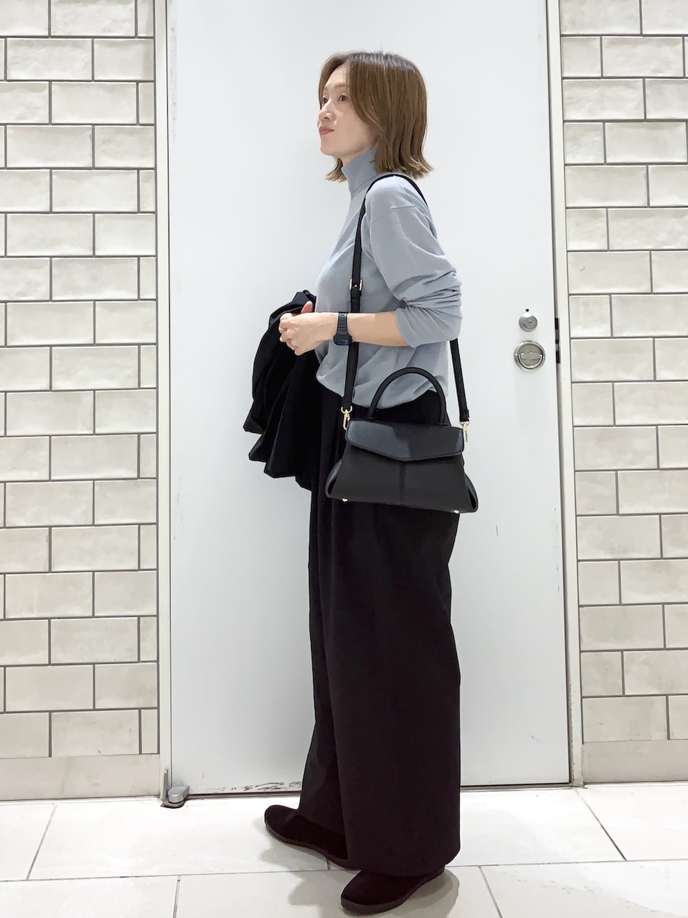 ブラック系のパンツ、ブラック系のテーラードジャケット、ブルー系のニット/セーターを着用したレディースの秋コーディネートの5枚目の写真