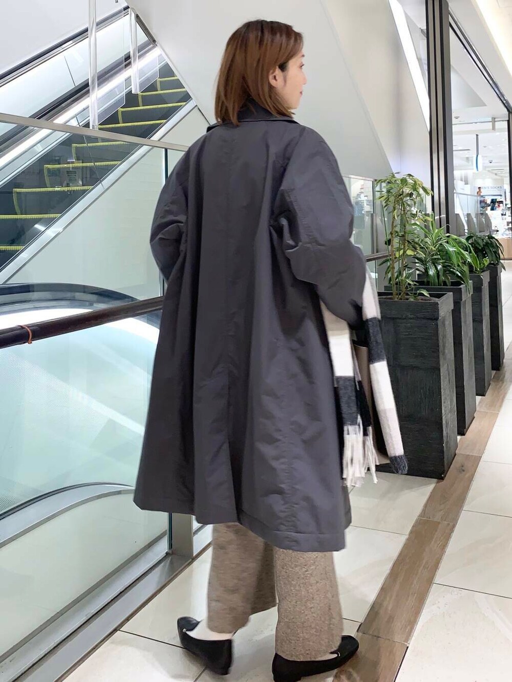 ブラック系のローファー、ブラック系のボストンバッグ、オレンジ系のニット/セーターを着用したレディースの秋コーディネートの3枚目の写真