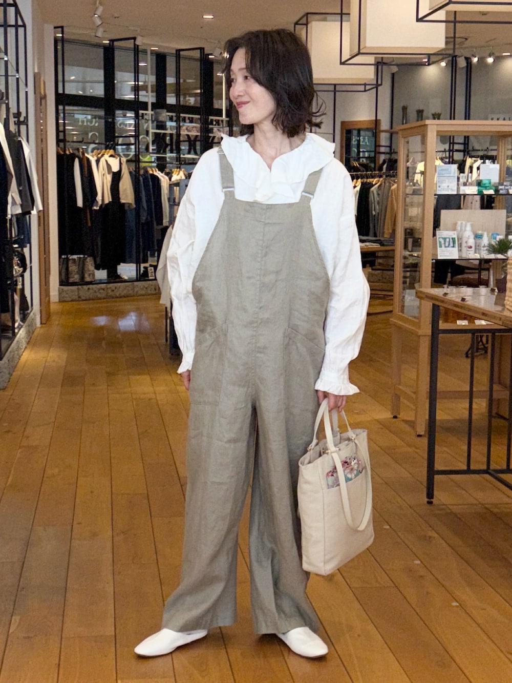 ブラック系のその他アウター、ホワイト系のシャツ/ブラウス、グレー系のサロペット/オーバーオールを着用したレディースの春コーディネートの2枚目の写真