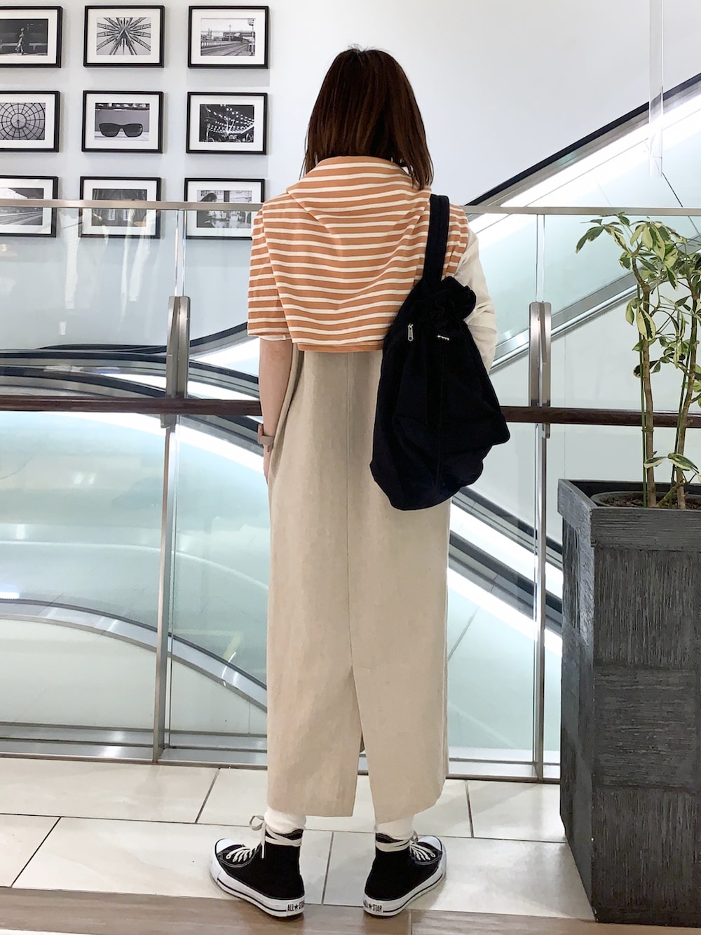 ベージュ系のワンピース、オレンジ系のTシャツ/カットソー、ホワイト系のTシャツ/カットソーを着用したレディースの春コーディネートの2枚目の写真