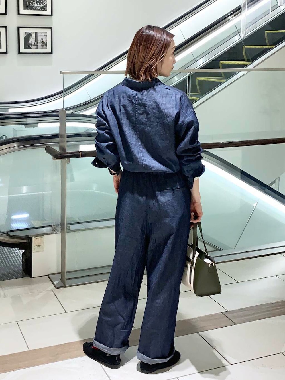 ベージュ系のTシャツ/カットソー、グリーン系のトートバッグ、ブルー系のサロペット/オーバーオールを着用したレディースの春コーディネートの5枚目の写真