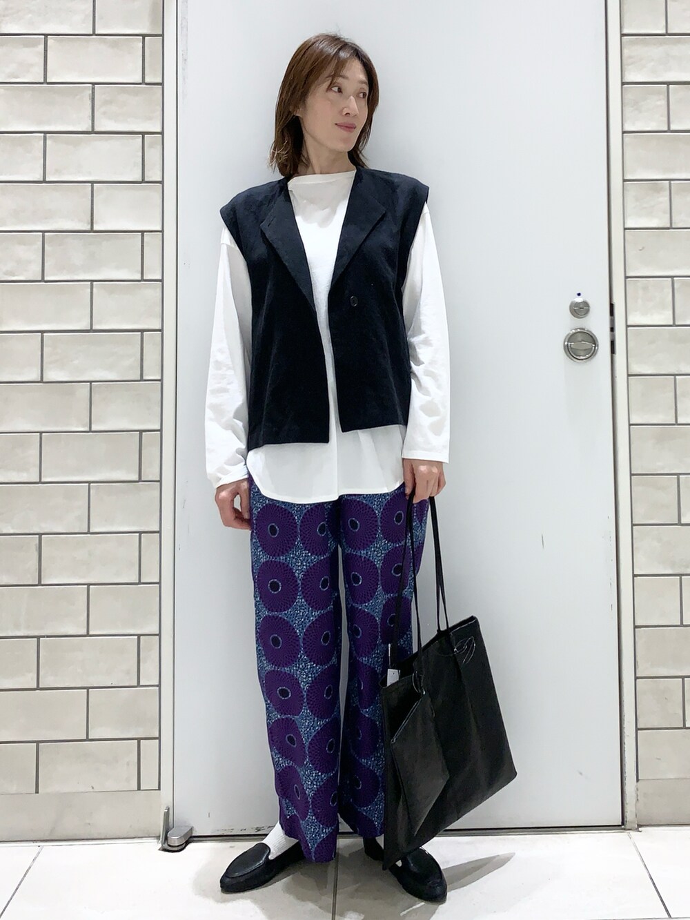 パープル系のその他パンツ、ブラック系のスリッポン、ブラック系のベストを着用したレディースの春コーディネートの4枚目の写真