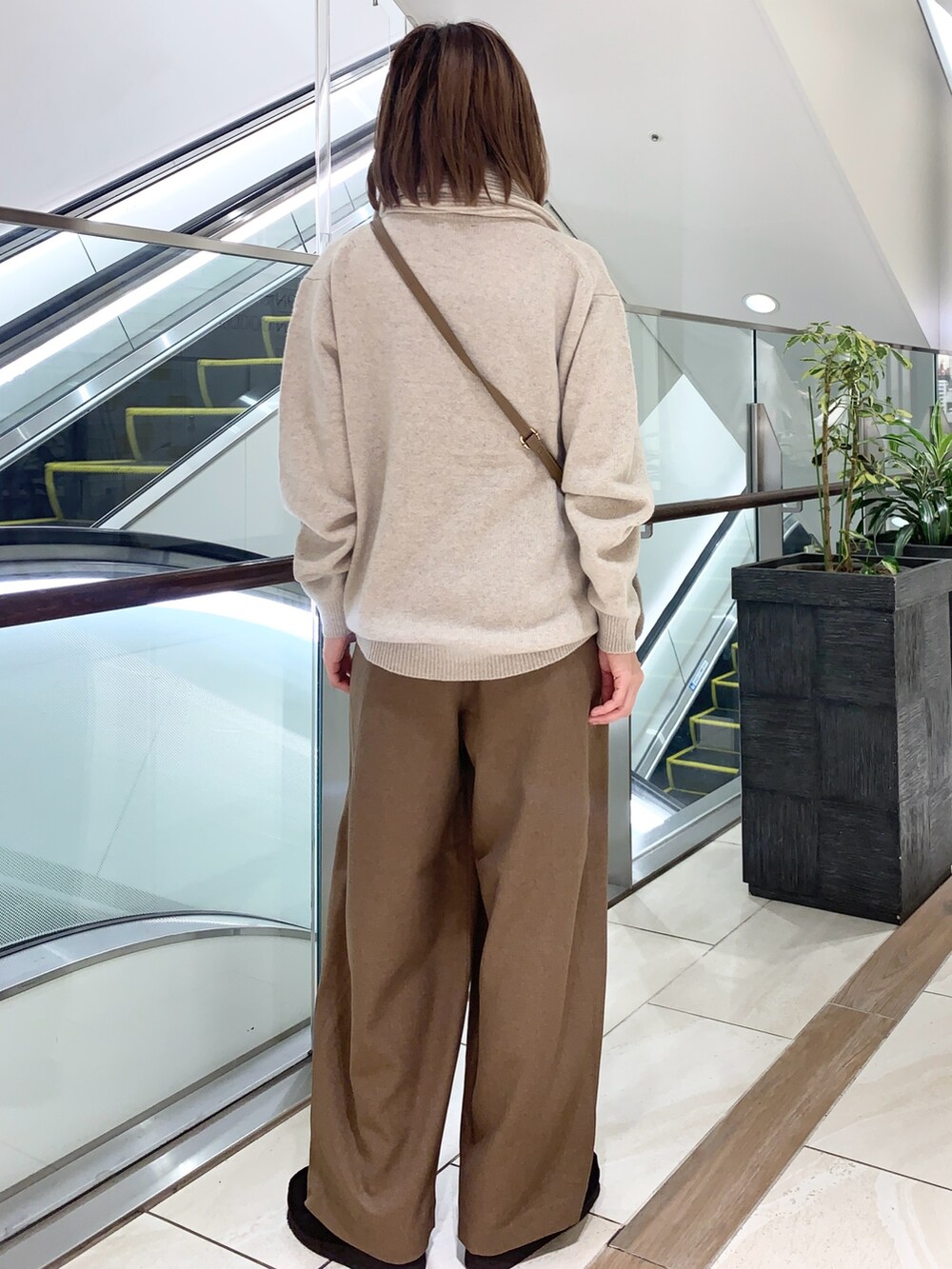 グレー系のその他パンツ、ベージュ系のニット/セーター、ブラウン系のショルダーバッグを着用したレディースの秋コーディネートの3枚目の写真