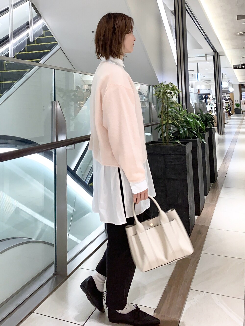 ピンク系のニット/セーター、ブラック系のその他パンツ、ホワイト系のシャツ/ブラウスを着用したレディースの秋コーディネートの6枚目の写真