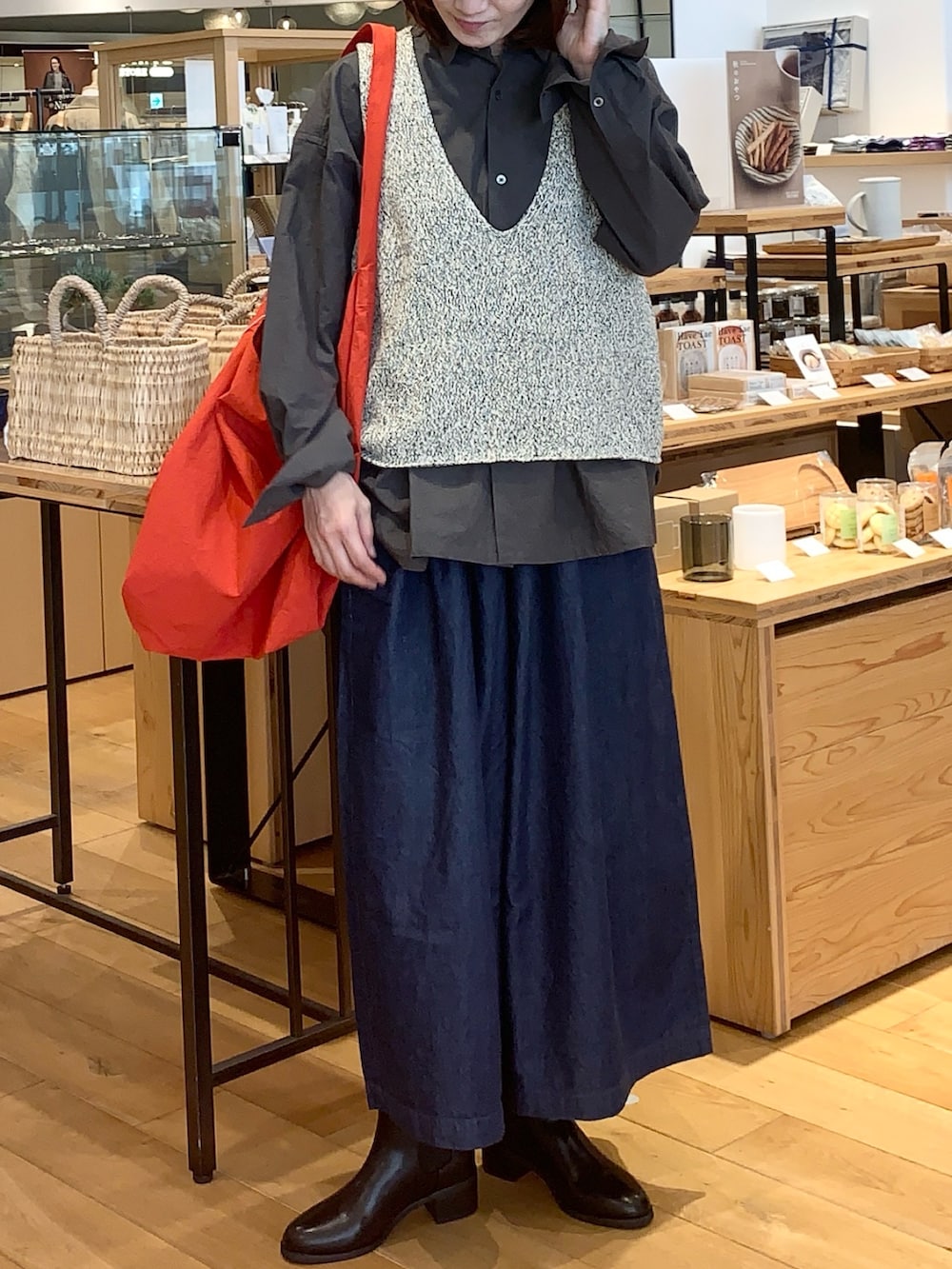 ブラック系のブーツ、グレー系のシャツ/ブラウス、ベージュ系のニット/セーターを着用したレディースの秋コーディネートの4枚目の写真