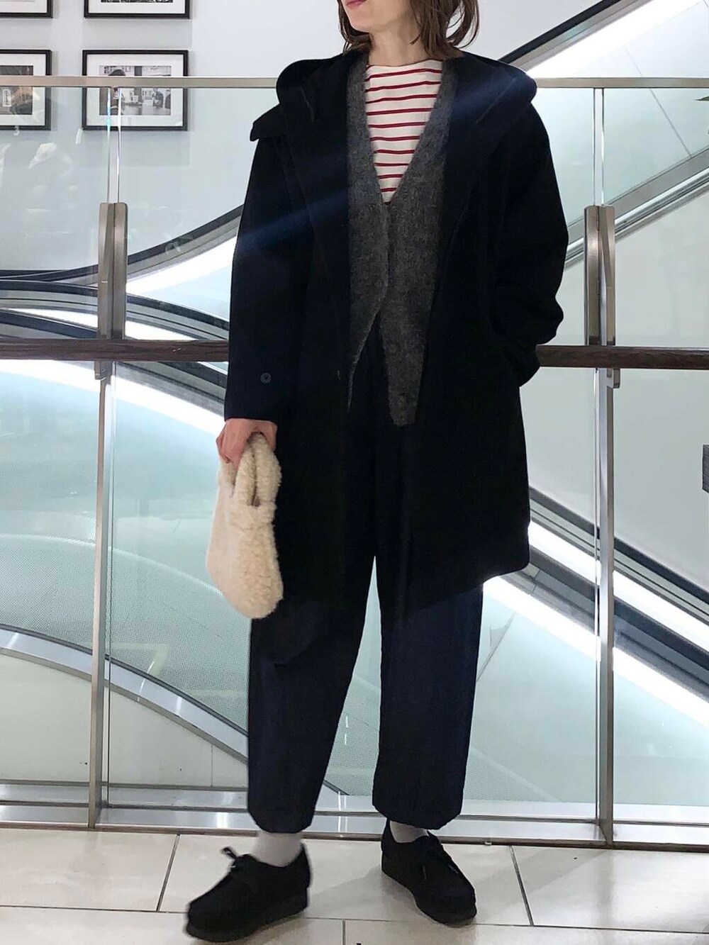 グレー系のカーディガン/ボレロ、レッド系のTシャツ/カットソー、ブルー系のデニムパンツを着用したレディースの冬コーディネートの5枚目の写真