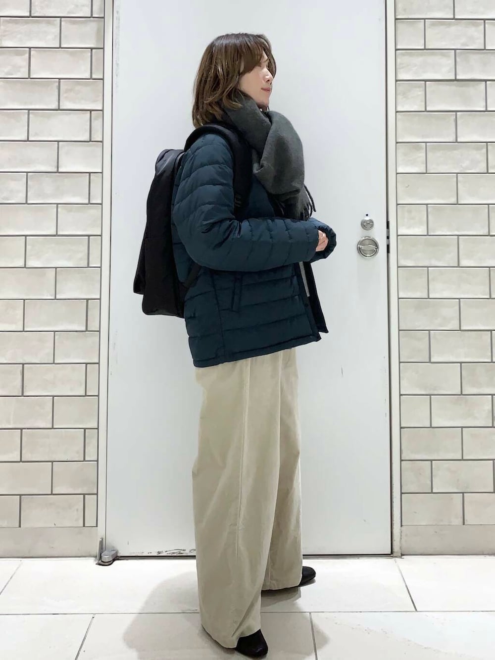 ブラック系のバックパック/リュック、ブルー系のダウンジャケット/コート、ブルー系のシャツ/ブラウスを着用したレディースの冬コーディネートの3枚目の写真