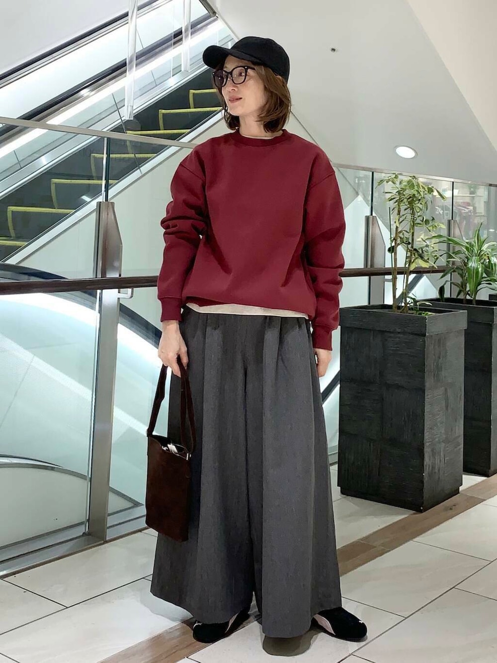 グレー系のその他パンツ、ブラウン系のショルダーバッグ、ベージュ系のTシャツ/カットソーを着用したレディースの冬コーディネートの2枚目の写真