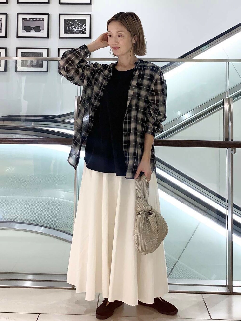 ブラック系のその他シューズ、ゴールド系のハンドバッグ、ブラック系のタンクトップを着用したレディースの夏コーディネートの3枚目の写真