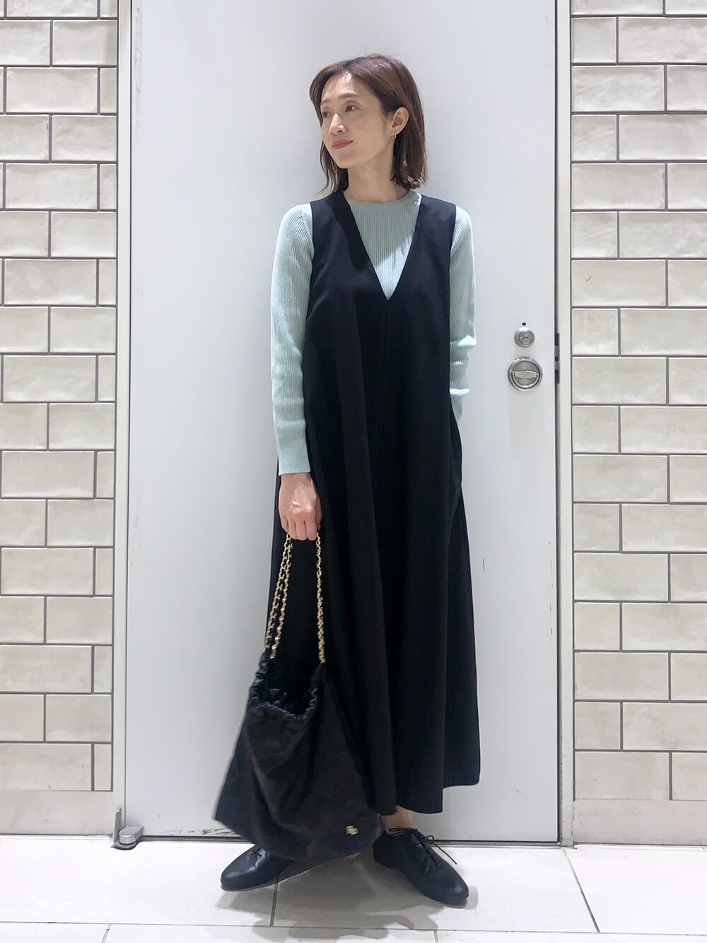 ブルー系のワンピース、グリーン系のニット/セーター、ブラック系のその他シューズを着用したレディースの春コーディネートの4枚目の写真