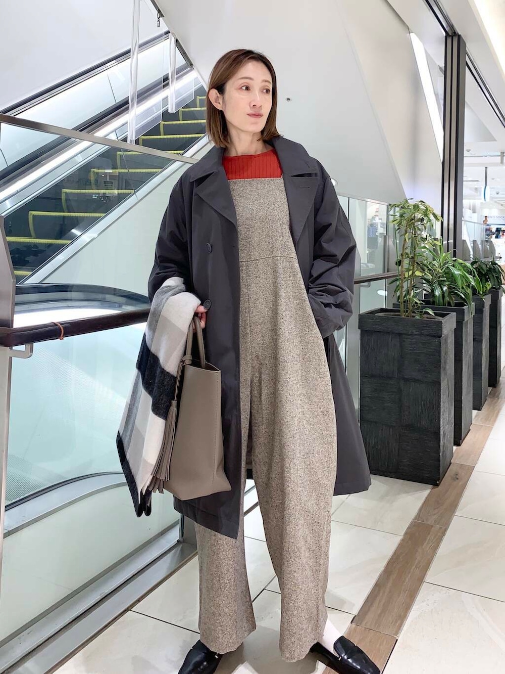 ブラック系のローファー、ブラック系のボストンバッグ、オレンジ系のニット/セーターを着用したレディースの秋コーディネートの4枚目の写真