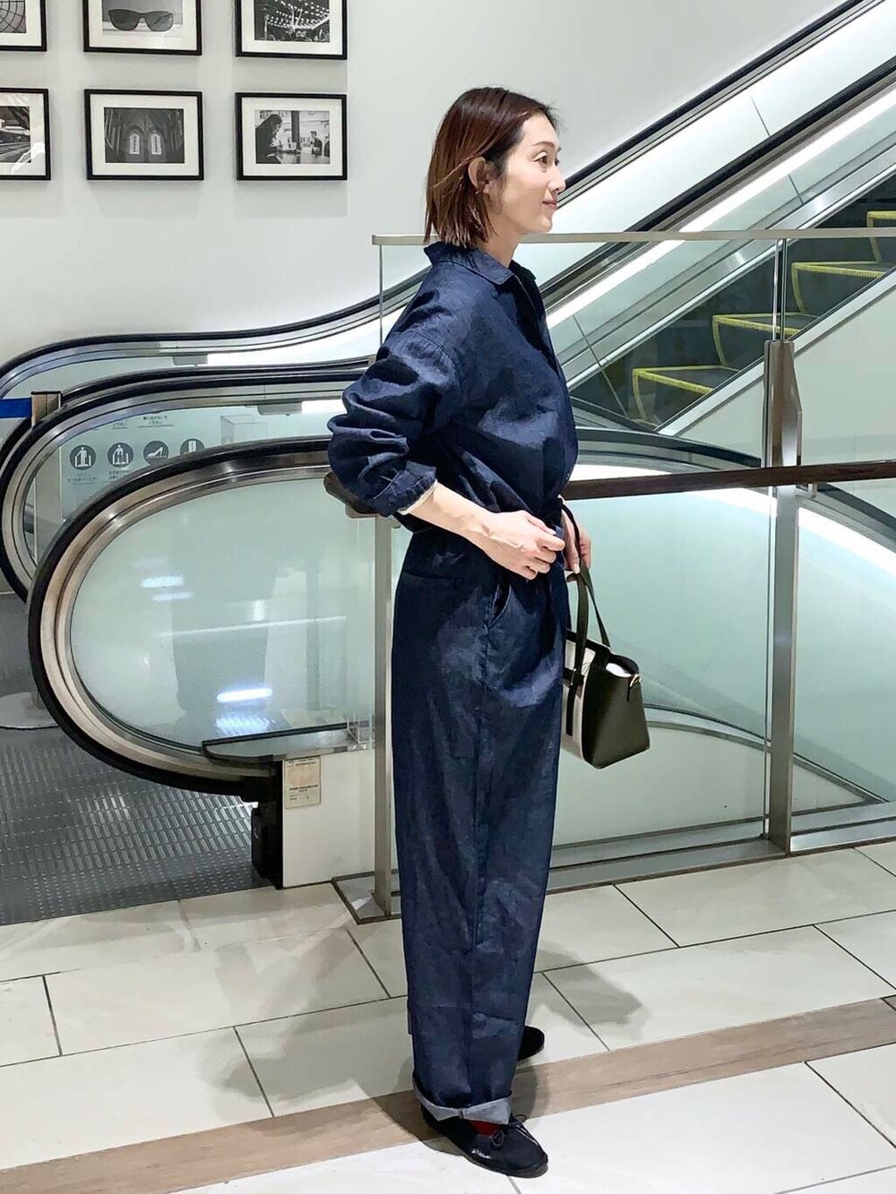 ベージュ系のTシャツ/カットソー、グリーン系のトートバッグ、ブルー系のサロペット/オーバーオールを着用したレディースの春コーディネートの4枚目の写真