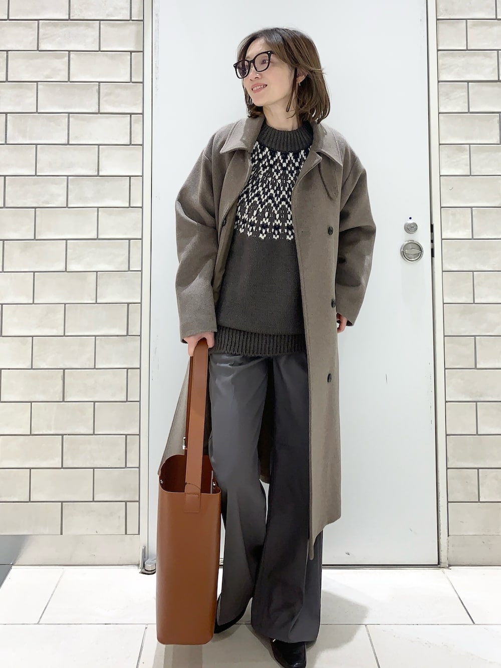 ブラウン系のその他アウター、グレー系のニット/セーター、グレー系のその他パンツを着用したレディースの冬コーディネートの2枚目の写真