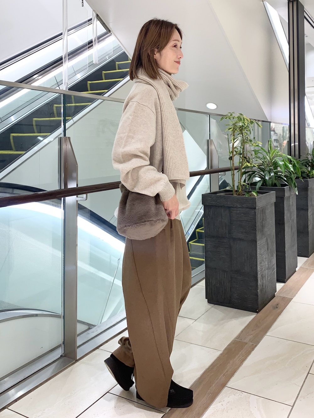 グレー系のその他パンツ、ベージュ系のニット/セーター、ブラウン系のショルダーバッグを着用したレディースの秋コーディネートの4枚目の写真