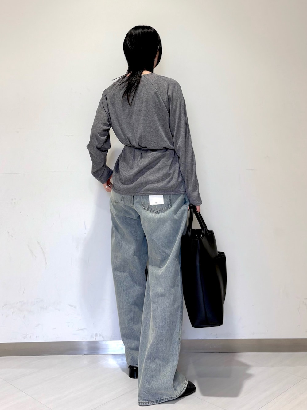 グレー系のTシャツ/カットソー、ブルー系のデニムパンツ、ブラック系のローファーを着用したレディースの冬コーディネートの2枚目の写真