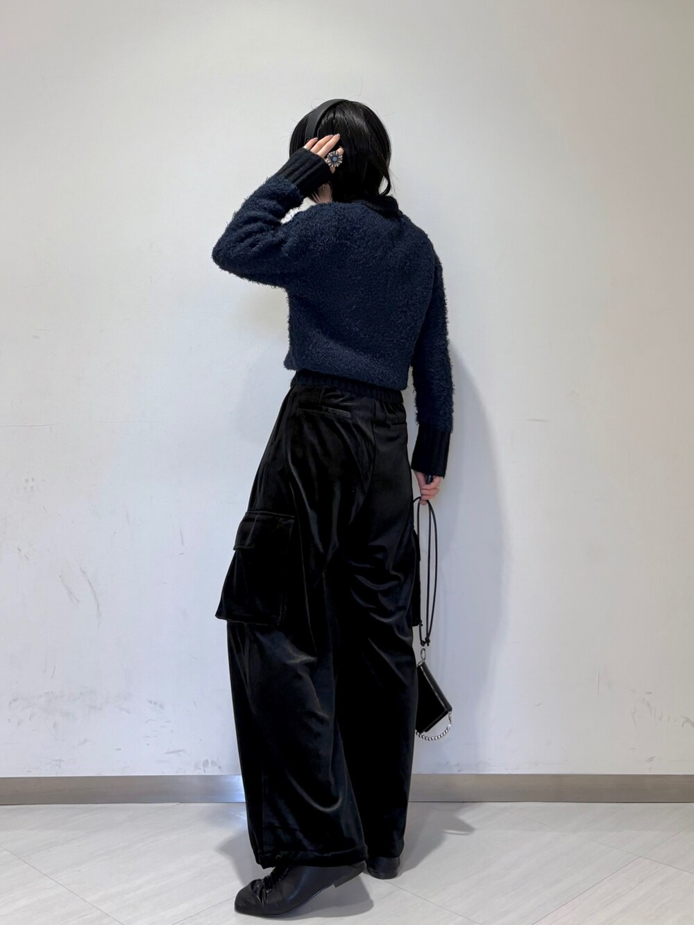 ブラック系のダウンジャケット/コート、ブルー系のニット/セーター、ブラック系のその他パンツを着用したレディースの冬コーディネートの4枚目の写真