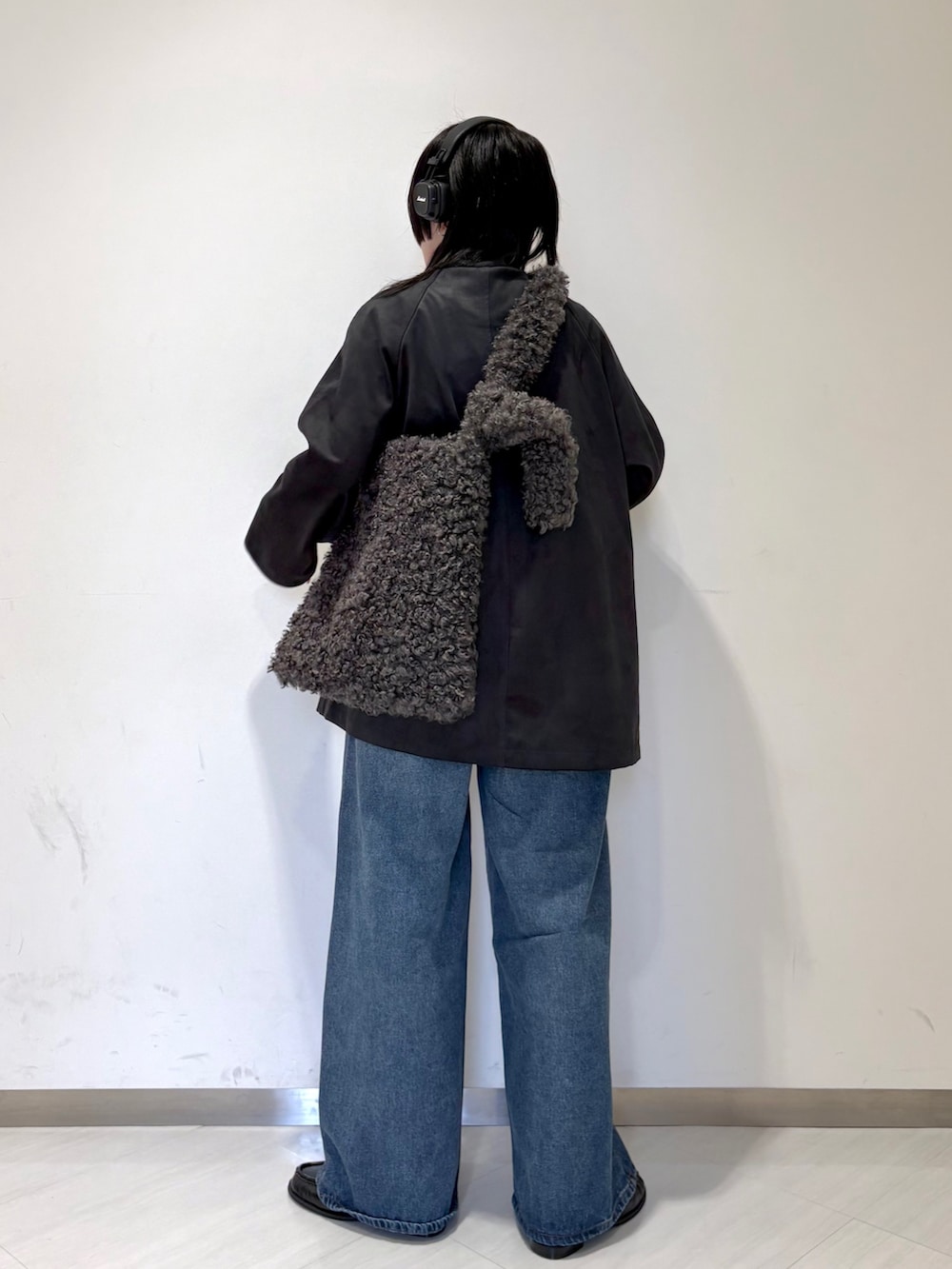 グレー系のカバーオール、グレー系のショルダーバッグ、ブルー系のデニムパンツを着用したレディースの秋コーディネートの2枚目の写真