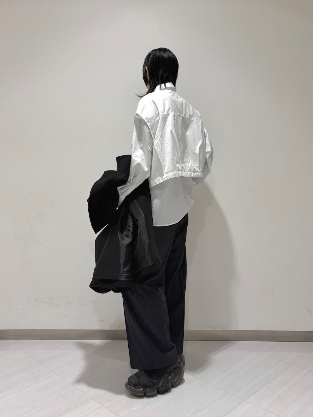 グレー系のその他パンツ、ブラック系のスニーカー、ホワイト系のシャツ/ブラウスを着用したレディースの冬コーディネートの3枚目の写真