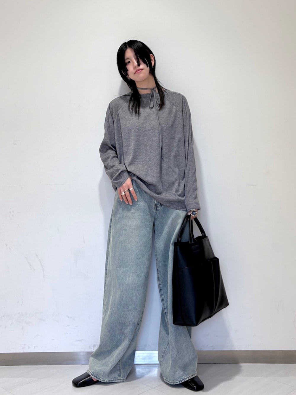 グレー系のTシャツ/カットソー、ブルー系のデニムパンツ、ブラック系のローファーを着用したレディースの冬コーディネートの3枚目の写真