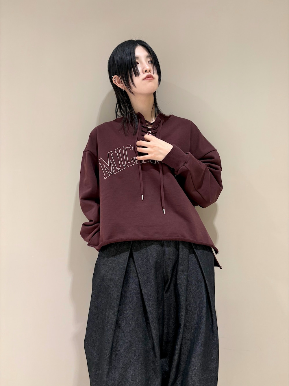 ブラウン系のスウェット、ブラック系のデニムパンツ、ブラック系のサンダルを着用したレディースの冬コーディネートの2枚目の写真