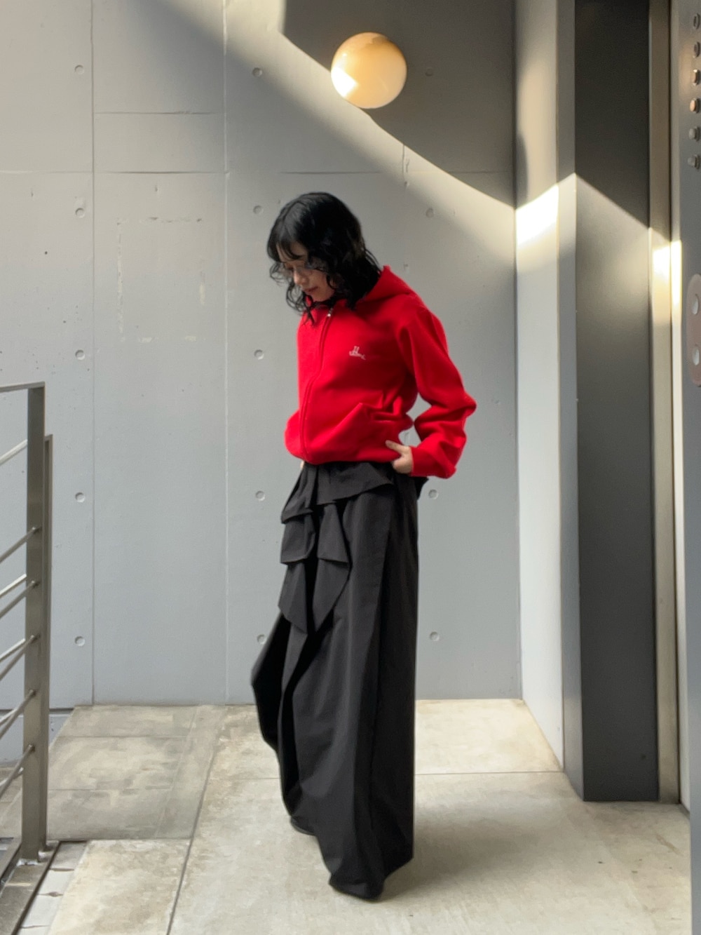 レッド系のニット/セーターを着用したレディースの冬コーディネートの2枚目の写真