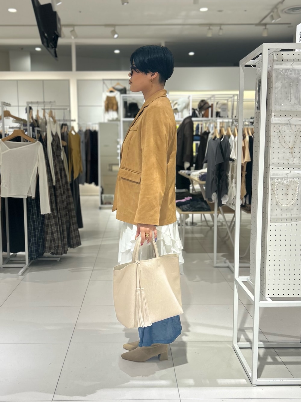 ホワイト系のスカート、ホワイト系のトートバッグ、ブルー系のワンピースを着用したレディースの秋コーディネートの2枚目の写真