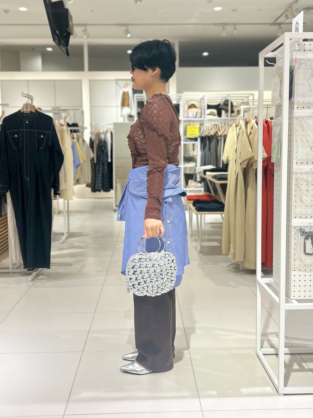 ブラウン系のデニムパンツ、シルバー系のハンドバッグ、シルバー系のその他シューズを着用したレディースの夏コーディネートの2枚目の写真