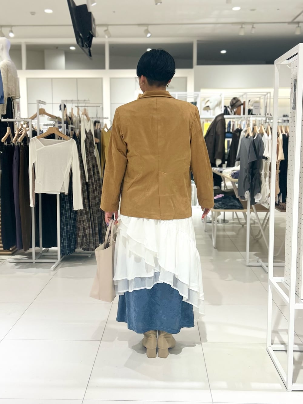 ホワイト系のスカート、ホワイト系のトートバッグ、ブルー系のワンピースを着用したレディースの秋コーディネートの3枚目の写真