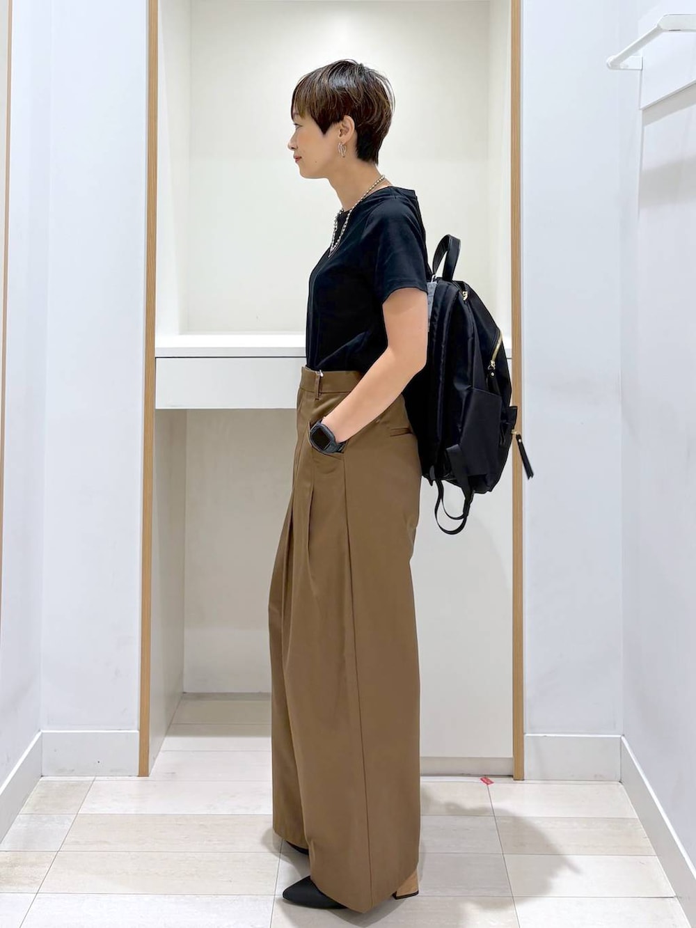 ブラック系のバックパック/リュック、ブラック系のTシャツ/カットソー、ブラック系のパンプスを着用したレディースの夏コーディネートの2枚目の写真