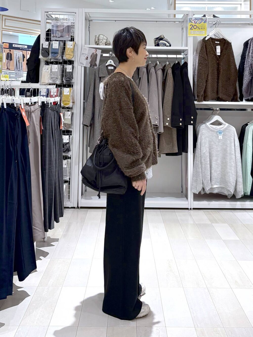 ブラック系のショルダーバッグ、ブラウン系のカーディガン/ボレロ、ホワイト系のTシャツ/カットソーを着用したレディースの秋コーディネートの2枚目の写真