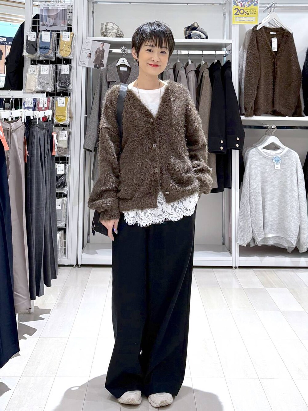 ブラック系のショルダーバッグ、ブラウン系のカーディガン/ボレロ、ホワイト系のTシャツ/カットソーを着用したレディースの秋コーディネートの4枚目の写真