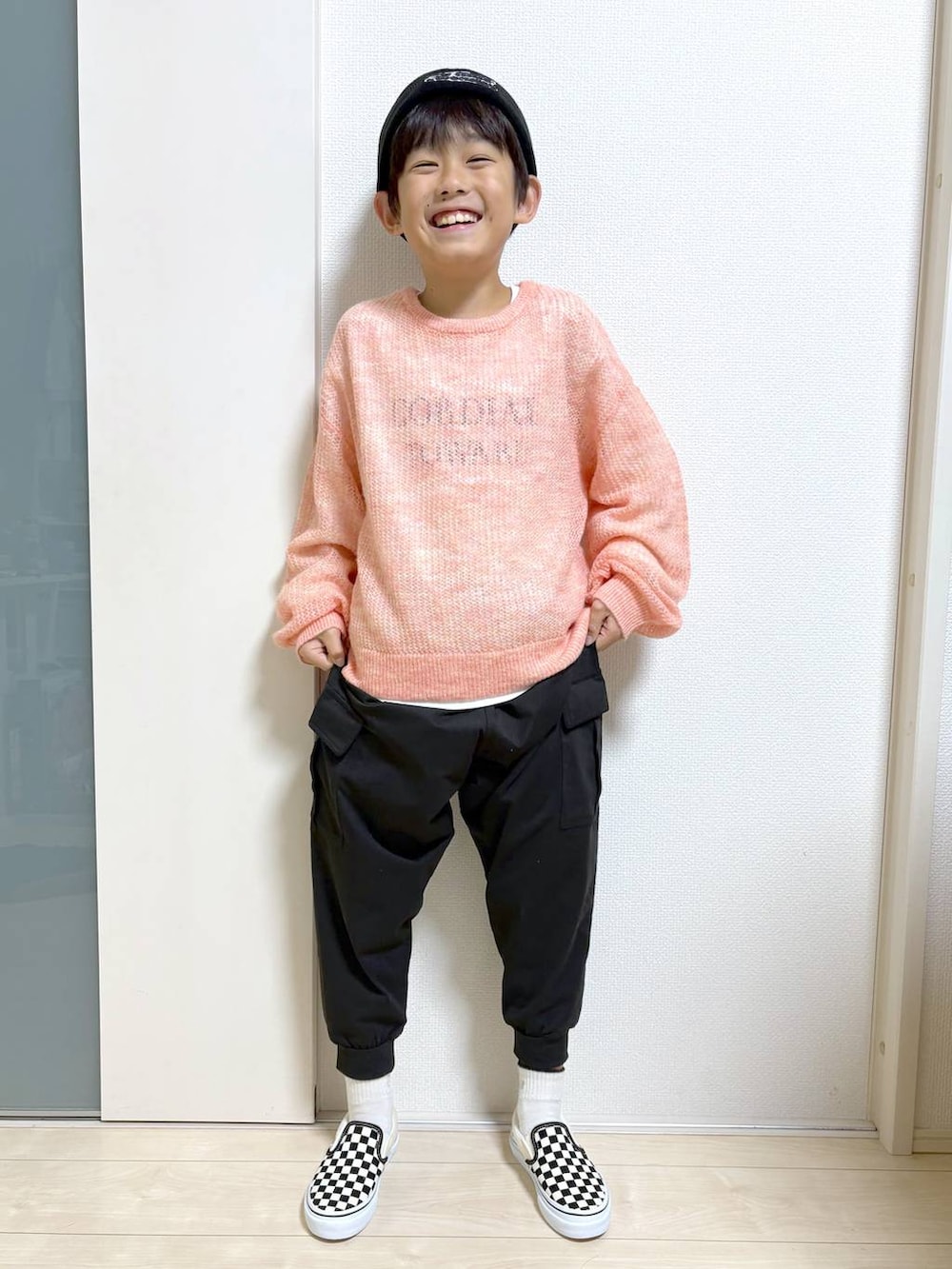 オレンジ系のニット/セーターを着用したキッズの秋コーディネートの2枚目の写真