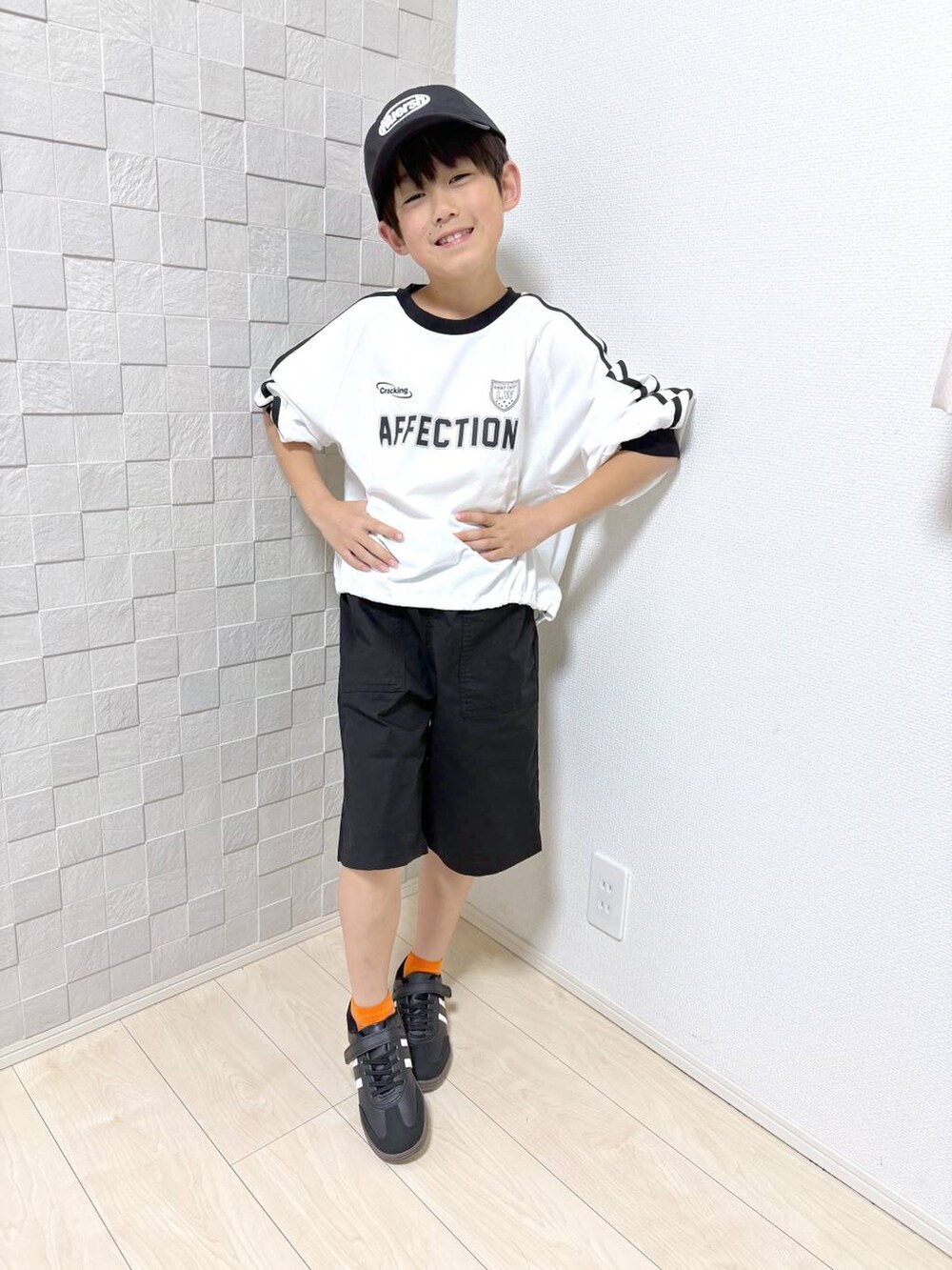 ブラック系のその他パンツ、ホワイト系のTシャツ/カットソーを着用したキッズの春コーディネートの4枚目の写真