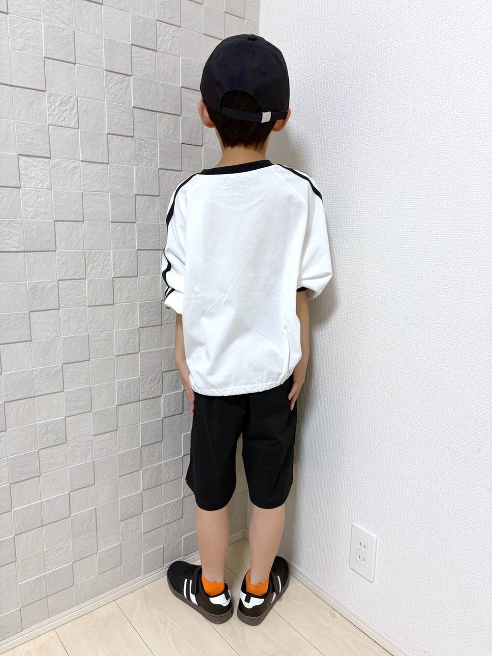 ブラック系のその他パンツ、ホワイト系のTシャツ/カットソーを着用したキッズの春コーディネートの3枚目の写真