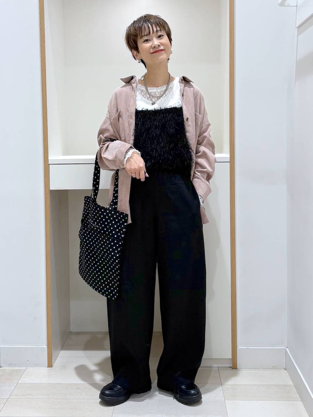 ブラック系のトートバッグ、ホワイト系のTシャツ/カットソー、ブラック系のその他パンツを着用したレディースの秋コーディネートの4枚目の写真
