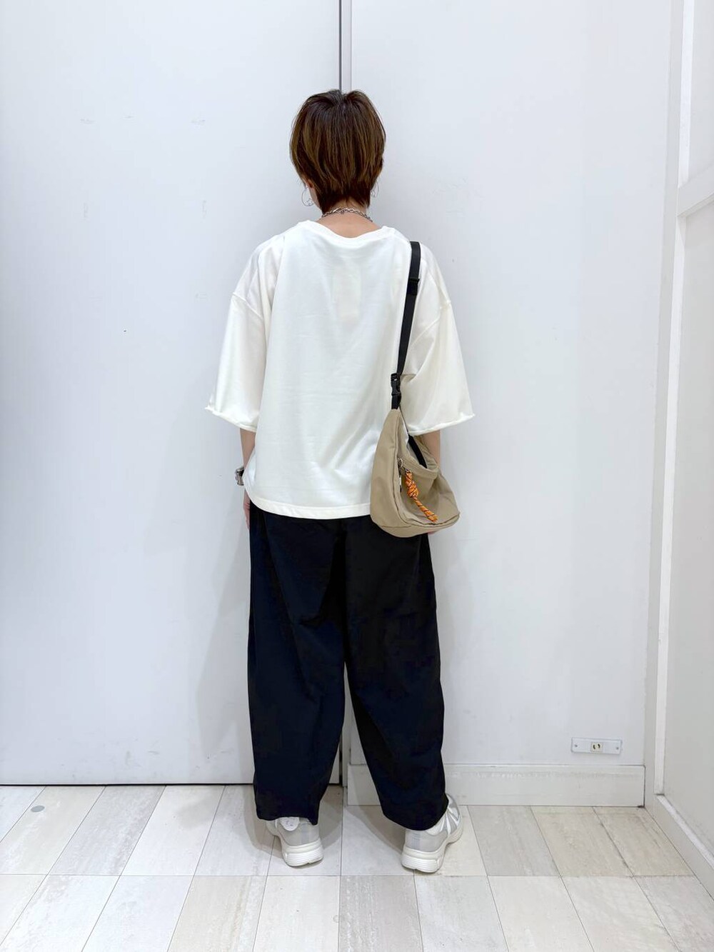 ブラック系のその他パンツ、ベージュ系のTシャツ/カットソー、ホワイト系のスニーカーを着用したレディースの春コーディネートの3枚目の写真