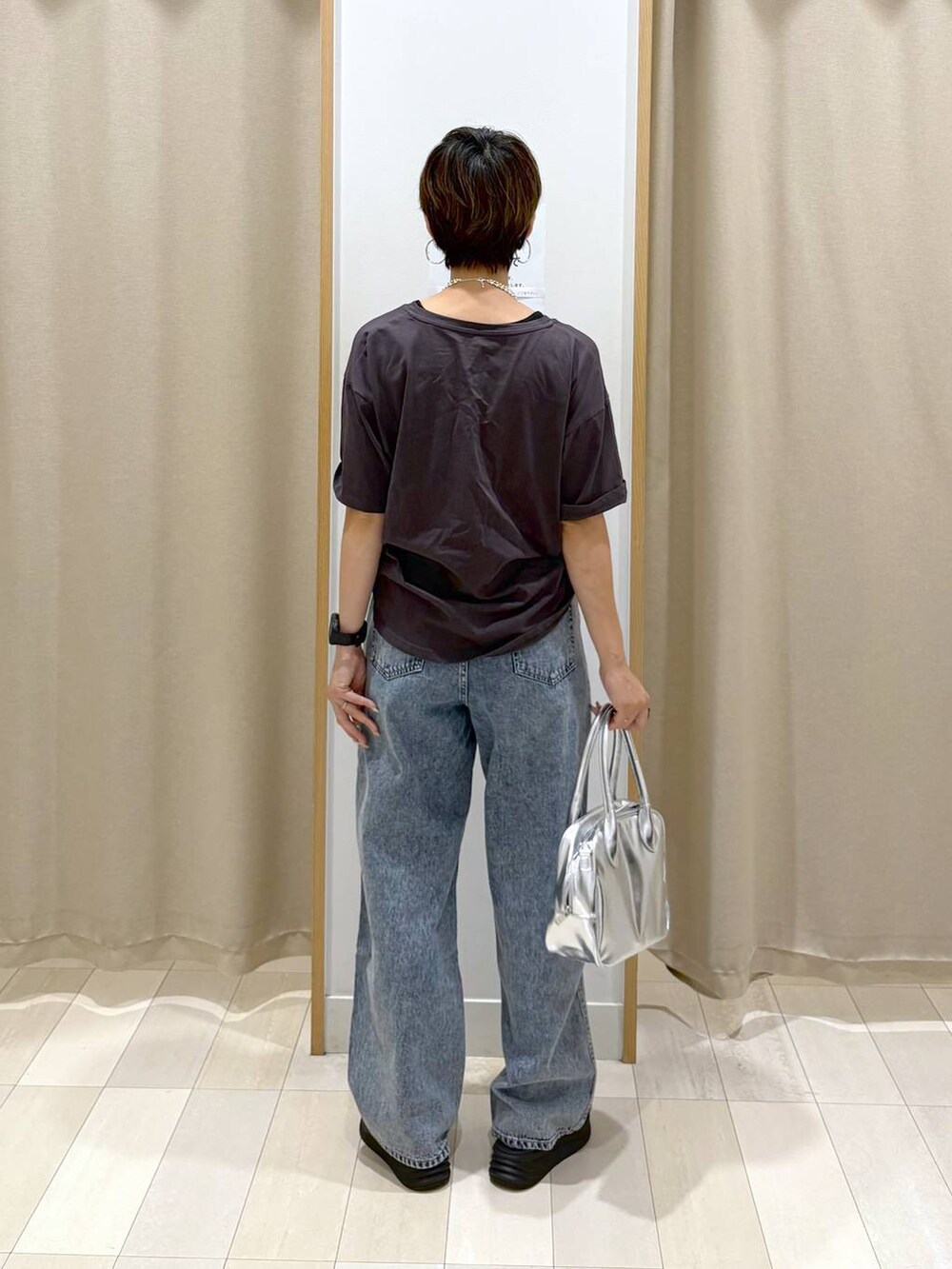 ブルー系のデニムパンツ、ブラック系のTシャツ/カットソー、グレー系のボストンバッグを着用したレディースの夏コーディネートの3枚目の写真