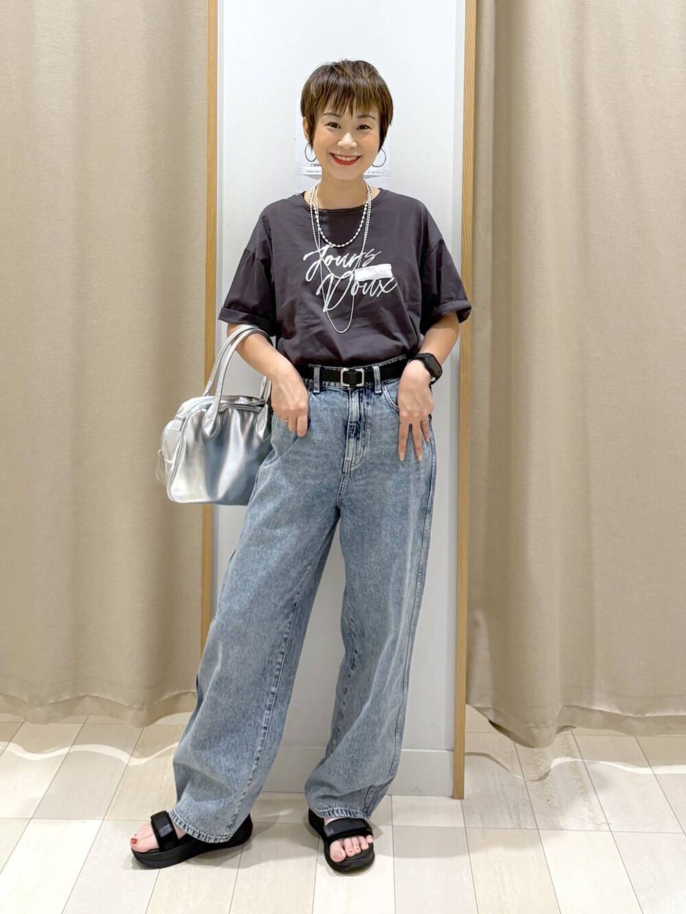 ブルー系のデニムパンツ、ブラック系のTシャツ/カットソー、グレー系のボストンバッグを着用したレディースの夏コーディネートの4枚目の写真