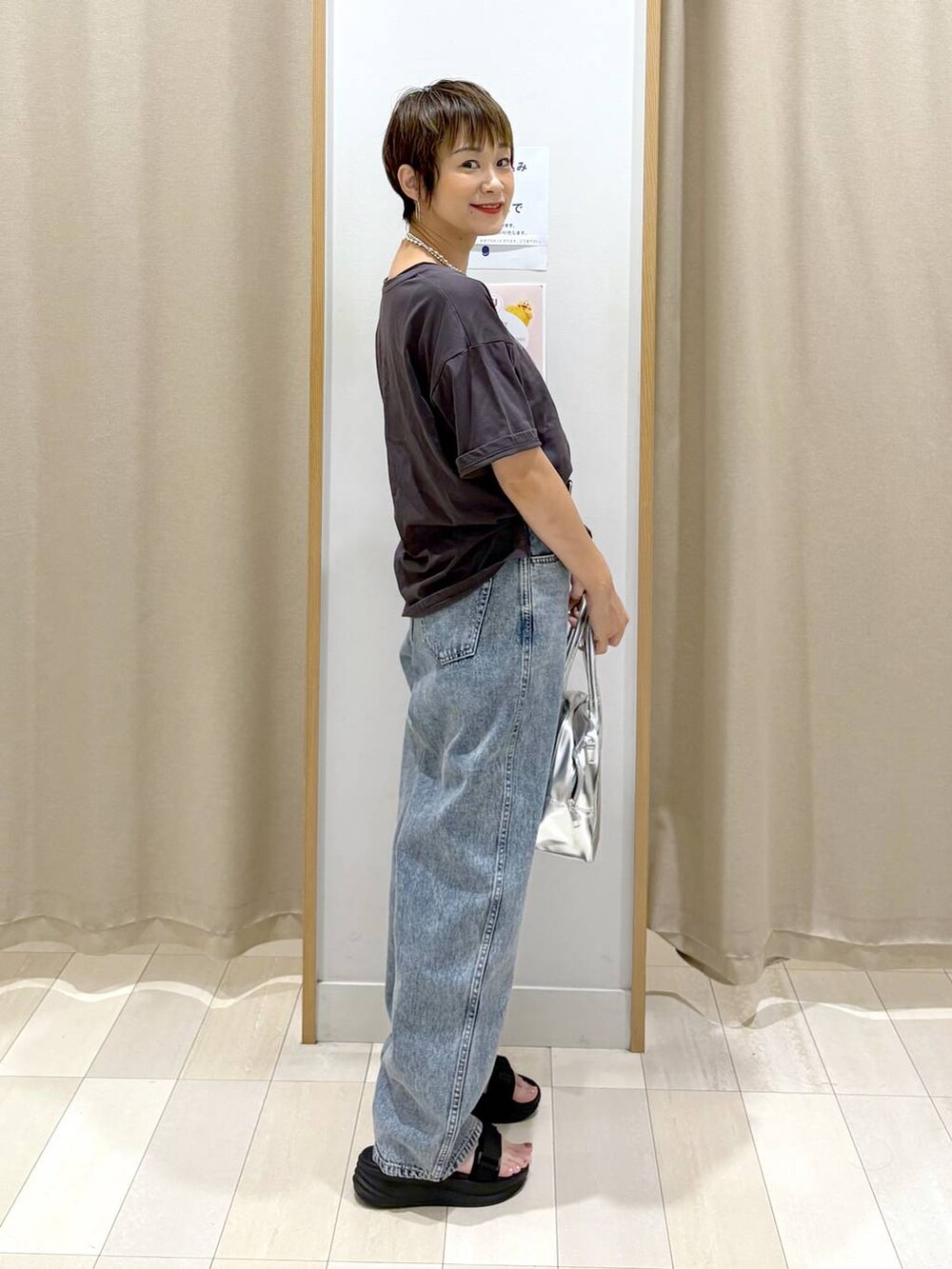 ブルー系のデニムパンツ、ブラック系のTシャツ/カットソー、グレー系のボストンバッグを着用したレディースの夏コーディネートの2枚目の写真