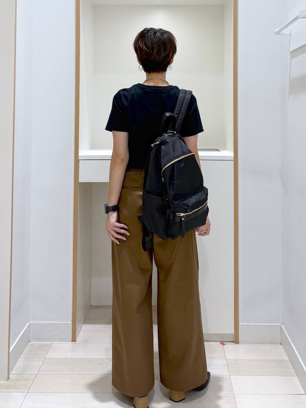ブラック系のバックパック/リュック、ブラック系のTシャツ/カットソー、ブラック系のパンプスを着用したレディースの夏コーディネートの4枚目の写真