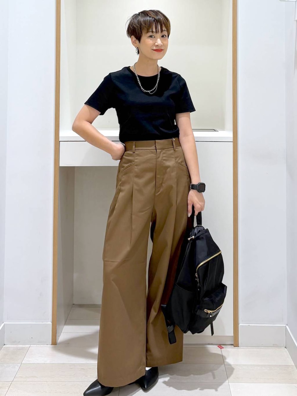ブラック系のバックパック/リュック、ブラック系のTシャツ/カットソー、ブラック系のパンプスを着用したレディースの夏コーディネートの5枚目の写真
