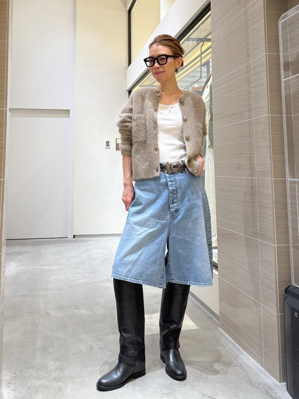 ブルー系のデニムパンツ、ベージュ系のカーディガン/ボレロ、シルバー系のネックレスを着用したレディースの夏コーディネートの5枚目の写真