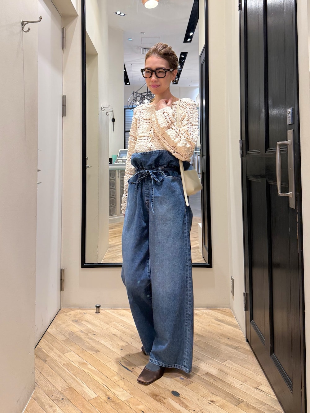 ブルー系のデニムパンツ、ホワイト系のカーディガン/ボレロ、ブラウン系のサンダルを着用したレディースの冬コーディネートの10枚目の写真