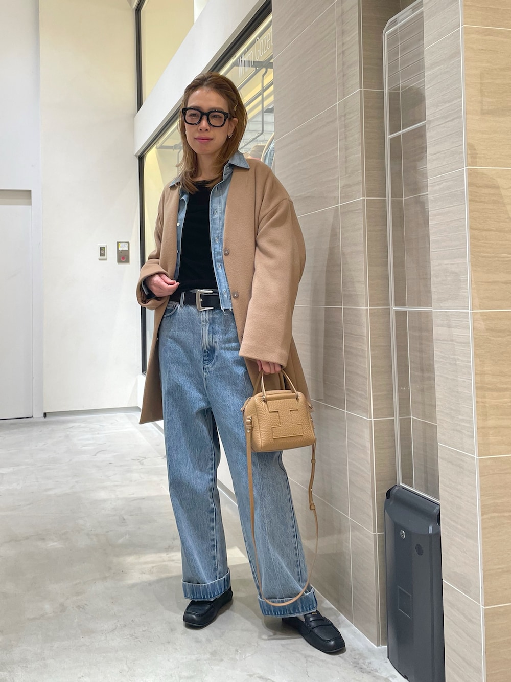 ブルー系のデニムパンツ、ブルー系のシャツ/ブラウス、イエロー系のノーカラーコートを着用したレディースの秋コーディネートの4枚目の写真